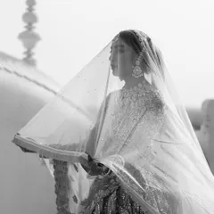 An ethereal black and white portrait of the bride under her veil. The soft focus and the architectural details in the background give this photo a timeless, dreamy quality.