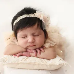 The iconic "head on hands" pose. It's a client favorite because it perfectly showcases the baby's delicate face and chubby cheeks. I ensure your baby is comfortable and safe while we create this timeless portrait.