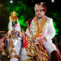 The classic groom's entry on a beautifully decorated horse. This shot captures the groom's proud and ready expression as he makes his way to the wedding venue.