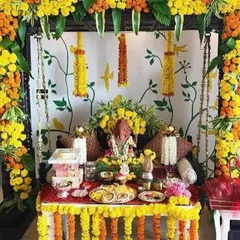 A beautiful Ganpati setup with a jhoola (swing) decorated heavily with yellow and orange marigold flowers.