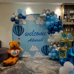 The personalized backdrop and balloon arch create a perfect spot for family photos.