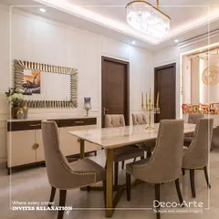 An elegant fusion of modern minimalism and classic detailing. This dining space features a sleek marble-top table, neutral-toned upholstery, and a statement chandelier to complete a look of sophisticated dining.