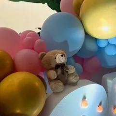 This whimsical baby shower featured large marquee letters, teddy bears nestled in pastel balloon clouds, and a custom hot air balloon prop, creating a dreamy and joyful atmosphere.