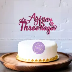 For the little "Threenager" in your life. This "Ajva is Threenager" topper in sparkling pink glitter acrylic adds a fun and sassy touch to any third birthday cake.