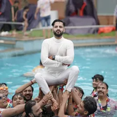 The groom being lifted up by his friends during a pool party. These celebrations are all about high energy and unforgettable moments with your loved ones.