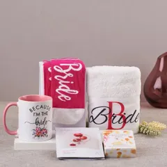 A close-up of a bride-to-be gift set, featuring a "Because I'm the Bride" mug, matching pink socks, a personalized towel, and a face mask for some pre-wedding relaxation.