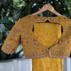 I designed this statement blouse with a unique heart-shaped cut-out back. The entire piece is covered in dense floral hand embroidery, making it a romantic and eye-catching choice for a bride.