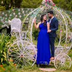 Another angle of the carriage prop, this time with the couple in a different pose and outfit. The groom-to-be embraces his partner, who is wearing a beautiful blue gown, creating a romantic pre-wedding portrait.