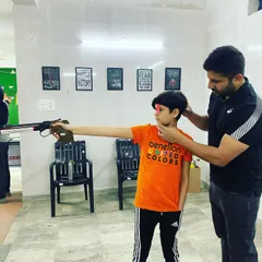 Every champion starts with the basics. Here, I am providing one on one instruction to a young shooter, correcting his stance and grip for the air pistol. I believe in building a strong technical foundation for shooters of all ages.