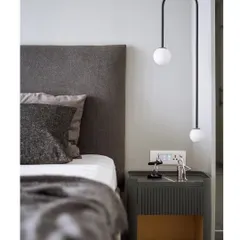 A close-up of the custom bedside table and suspended light. The fluted detail on the table and the simple geometry of the light fixture showcase our attention to craftsmanship and detail.
