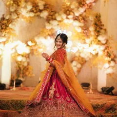 A full-length portrait of the bride, Proneeta, twirling in her gorgeous red and yellow lehenga. This shot captures the grandeur of her outfit and her joyful spirit.