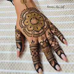 A striking mandala design centered on the back of the hand, featuring a large, detailed floral pattern. The fingers are adorned with complementary patterns and solid tips for a bold look.