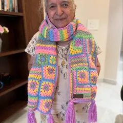 For those who love pastel colors, this granny square muffler is a dream. The soft shades of pink, blue, yellow, and purple create a gentle, pretty look, completed with lilac tassels.