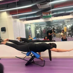 A student gracefully holds a variation of Shalabhasana (Locust Pose) on a back-bending bench, a prop that helps to open the chest and strengthen the entire back body.