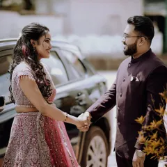 The couple holding hands by their car, sharing a look of love and excitement for the journey ahead.