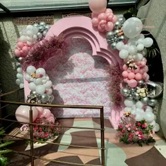A wider view of the Dior-themed entrance decor. This shows how the arched backdrop, balloon arrangements, and floral accents work together to create an immersive and photogenic entryway for the event.