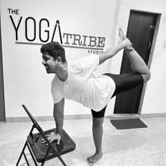 Demonstrating Natarajasana (Dancer's Pose) with the help of a chair. This is a great way to work on your balance and backbend without pressure.