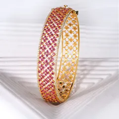 Let the vivid glow of this ruby bangle elevate your spirit. Hundreds of hand-set rubies create a tapestry of colour, framed by brilliant diamonds. The intricate floral pattern on the inside of the gold band is a hidden detail, just for the wearer.