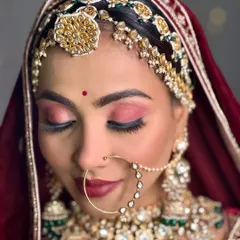 A detailed close-up of the bridal makeup. Notice the flawless base, the rich matte red lip, and the perfectly blended eyeshadow, all coming together for a majestic look.