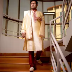 A classic portrait of the groom in his traditional Indian attire. He is captured walking down a staircase, looking elegant and ready for the ceremony.