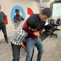Participants at our Hitachi workshop practicing a technique to escape a bear hug from behind. These are practical skills for real-world scenarios.