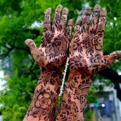 A very dense and intricate floral design that covers the entire hand. The dark stain makes the detailed patterns pop, creating a very dramatic and beautiful effect.