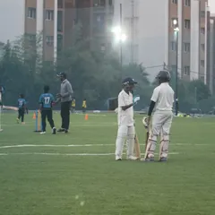 Two young players from our U10 cricket team discuss strategy during a practice match. These games are essential for developing on-field communication and tactical awareness.
