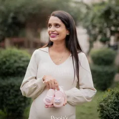 An outdoor maternity portrait session allows for beautiful, natural light. Here, we captured a joyful solo shot of the mom-to-be, highlighting her happiness and anticipation with some cute baby shoes as a prop.