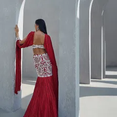 The back view of a crimson lehenga with pearl-drenched seams, paired with a crushed dupatta that speaks in whispers of modern elegance.