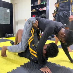 Rolling with purpose, sparring with skill. A student works to pass the guard during a BJJ session. This is where mastery begins.