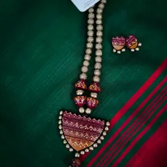 A brand new terracotta design. This necklace set features a semi-circular pendant with intricate geometric patterns in warm, earthy tones, paired with matching earrings.