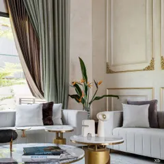 We carefully selected every piece of decor to complement the room's grand aesthetic. Here, the soft textures of the sofa and curtains contrast with the metallic accents of the side tables.