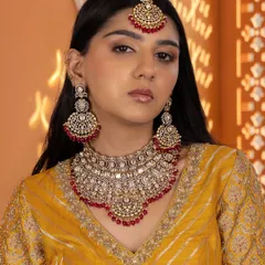 This full view highlights the grandeur of our red Kundan bridal set, complete with a statement choker, matching chandbali earrings, and an ornate maang tikka.