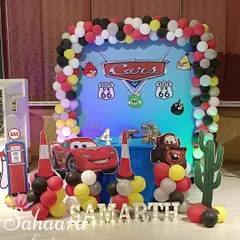 Ready, set, go! A high-energy 'Cars' themed birthday decoration for a 4th birthday. The setup includes a Lightning McQueen cutout, a balloon arch in the theme's colors, and Route 66 signs.