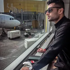 The grind often involves catching flights between gigs. A quiet moment at the airport before heading to the next city, ready to bring the energy.
