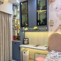A closer look at the study unit in the kids' room, with blue cabinets, glass display shelves for toys, and a sleek, wall-mounted desk.