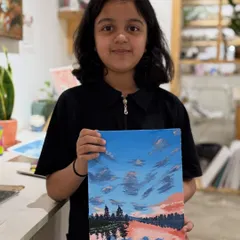 A young artist with her beautifully detailed landscape painting. In our sessions, I encourage kids to explore techniques for painting things like skies, water, and reflections.