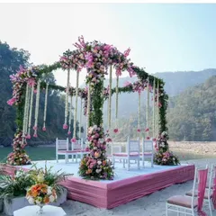 This is a floral mandap we designed for a destination wedding in Rishikesh. The structure is covered in lush greenery and flowers, perfectly complementing the natural beauty of the riverside location.