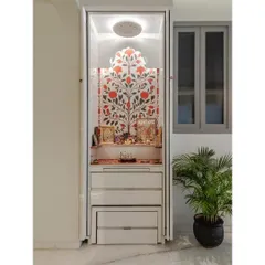 This compact pooja unit shows how a sacred space can be integrated seamlessly into a modern home. Featuring a beautiful tree-of-life wallpaper backdrop and a glossy white acrylic finish, the unit includes multiple drawers for storage and can be concealed with pocket doors, making it both beautiful and space-efficient.
