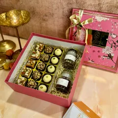 Our 'Bliss Box' is handcrafted with pure ingredients like desi ghee and homemade mawa. It includes a delightful assortment of roasted almond truffles, coconut ladoos, and rose pistachio shortbread.