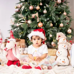 A classic portrait from a first birthday Christmas shoot. The beautifully decorated tree, the festive props, and her adorable Santa hat all come together to create a picture-perfect holiday memory.