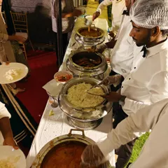 Our uniformed staff serving guests at a buffet line. We focus on providing a smooth, hygienic, and professional service so you can focus on your event.