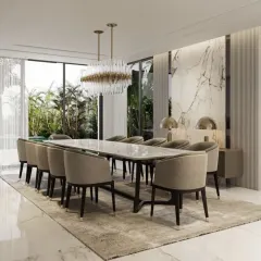 We designed this expansive dining room for elegant entertaining, featuring a ten-seater marble-top table and plush upholstered chairs. A dramatic crystal chandelier hangs above, while the marble accent wall and large windows create a bright, sophisticated atmosphere perfect for hosting memorable dinners.