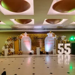 Another angle of the 55th birthday party decor, showing how the different elements like the shimmer wall, custom signs, and balloon arrangements come together to create a full party scene.
