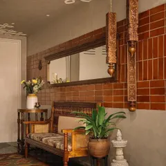 The private foyer of the 'Brihati' home welcomes you with the warmth of brick, oxide walls, and vintage-inspired furniture. I took the traditional 'kolam' and gave it an unconventional twist by mounting a larger-than-life version on the ceiling, creating an immediate sense of arrival.