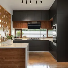Our award-winning kitchen designs focus on clean lines, smart functionality, and natural light. This kitchen from the Cube House project uses a contrasting palette of dark laminates and warm wood, with an open layout and large window to create an efficient and inviting cooking space.