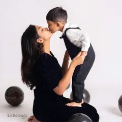 A sweet kiss from son to mom during his birthday photoshoot. This tender moment, captured amidst the celebration, is a memory to treasure.
