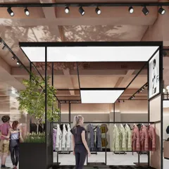 A render for an apparel store in Noida, showing a "shop-in-shop" concept with black metal framing and integrated lighting. The design incorporates planters to bring a touch of nature into the retail environment.