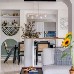For this open-plan home, creating a sense of connection was key. I designed a breakfast bar that acts as a gentle partition between the living and dining areas, perfect for casual meals or conversations. The space is filled with natural light and thoughtful details like a custom wine rack and contemporary chairs, making it ideal for hosting friends and family.