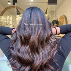 A perfect example of how highlights can add dimension to dark hair. We created these rich, caramel and light brown streaks, blending them seamlessly into the natural base color and styling them into soft waves to showcase the texture.
